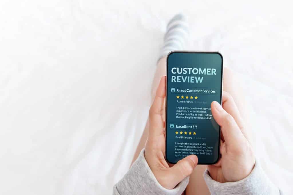 Customer Experience Concept. Woman lying on Bed to Reading Onlin Customer Experience Concept. Woman lying on Bed to Reading Online Review via Smartphone before Buying Products and Services, More Positive Feedback on Mobile Screen
